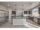 Bright kitchen features stainless appliances, granite island, and tile floors at 9876 Parador Cellars Ct, Las Vegas, NV 89141
