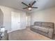 Living room with a couch, large television, ceiling fan, and carpet at 9876 Parador Cellars Ct, Las Vegas, NV 89141
