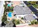 Aerial view showcases the backyard's pool, spa, and patio area, surrounded by lush landscaping and mature palm trees at 9905 Fox Springs Dr, Las Vegas, NV 89117