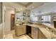 Elegant bar area featuring custom cabinetry, granite counters, wine storage, and convenient access to entertaining spaces at 9905 Fox Springs Dr, Las Vegas, NV 89117