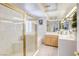 Well-lit bathroom featuring a glass-enclosed shower, soaking tub, and dual vanities at 9905 Fox Springs Dr, Las Vegas, NV 89117