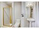 Bright bathroom featuring a glass-enclosed shower, pedestal sink, and modern fixtures at 9905 Fox Springs Dr, Las Vegas, NV 89117