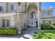 Close-up of an elegant front entrance, showcasing double doors and a well-manicured yard with mature trees at 9905 Fox Springs Dr, Las Vegas, NV 89117