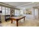 Bright game room featuring a pool table, windows with shutters, and view of the kitchen/dining area at 9905 Fox Springs Dr, Las Vegas, NV 89117