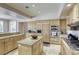 Well-lit kitchen featuring an island, granite countertops, modern appliances, and light wood cabinetry at 9905 Fox Springs Dr, Las Vegas, NV 89117