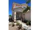 Charming front entryway features a covered porch, decorative iron door, and a well-manicured garden at 9940 Trailing Vine St, Las Vegas, NV 89183