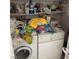 A laundry room with front loading machines and storage shelves at 9940 Trailing Vine St, Las Vegas, NV 89183