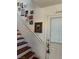 A cozy staircase adorned with a collection of framed photos, leading to a white door with a rustic moon decoration at 9940 Trailing Vine St, Las Vegas, NV 89183
