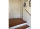 Classic staircase with wood steps and white risers, complemented by white walls and decorative artwork at 9940 Trailing Vine St, Las Vegas, NV 89183