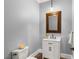 Elegant powder room featuring a framed mirror, white vanity, and decorative accents at 1 Dry Brook Trl, Henderson, NV 89052