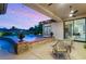 Relaxing covered patio featuring comfortable seating and a refreshing pool view at dusk at 1 Dry Brook Trl, Henderson, NV 89052