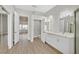 Spacious bathroom features double sinks, white cabinets, and stylish wood-look flooring at 10700 Button Willow Dr, Las Vegas, NV 89134