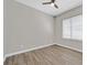 Bedroom featuring a window, base trim, ceiling fan, and hard surface floors at 10700 Button Willow Dr, Las Vegas, NV 89134