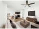 Open-concept living room with ceiling fan flows into kitchen with dining area and stairs at 12112 Polar White Ct # 3, Las Vegas, NV 89183