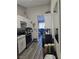 Galley-style kitchen with white cabinetry, stainless steel appliances, and wood-look flooring at 1713 Fairfield Ave, Las Vegas, NV 89102