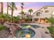Inviting backyard features a pool, spa, rock features, and mature palm trees at 2221 Grier Woods Ct, Las Vegas, NV 89134
