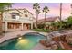 Spacious backyard featuring pool, spa, rock features, and lush landscaping at 2221 Grier Woods Ct, Las Vegas, NV 89134