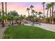 Tranquil backyard featuring a pool with a rock waterfall and lush landscaping at 2221 Grier Woods Ct, Las Vegas, NV 89134