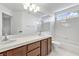 Bright bathroom featuring double sinks, white tile, and a shower-over-tub at 2221 Grier Woods Ct, Las Vegas, NV 89134