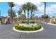 Gated community entrance with a center fountain, mature trees and professional landscaping at 2221 Grier Woods Ct, Las Vegas, NV 89134