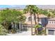 Two-story home featuring a three-car garage, tile roof and well-manicured landscaping at 2221 Grier Woods Ct, Las Vegas, NV 89134