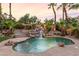 Beautiful pool with rock waterfall and lush landscaping, creating a serene oasis at 2221 Grier Woods Ct, Las Vegas, NV 89134
