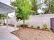Backyard with white pergola, rock landscaping, brick flower bed border, and mature tree at 2705 Chokecherry Ave, Henderson, NV 89074