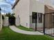 Exterior side view of home featuring walkway to iron gate, fenced yard, and stucco siding at 2705 Chokecherry Ave, Henderson, NV 89074