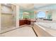Elegant bathroom featuring a soaking tub, glass-enclosed shower, marble floors, and mirrored walls at 2747 Paradise Rd # 2704, Las Vegas, NV 89109
