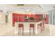 Modern kitchen featuring sleek, red cabinetry, a black countertop island, and stainless steel appliances at 2747 Paradise Rd # 2704, Las Vegas, NV 89109