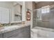 Bathroom features vanity with gray cabinets and shower-tub combo at 3120 Darby Falls Dr, Las Vegas, NV 89134