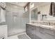 Modern bathroom featuring a double vanity with gray cabinets and a glass-enclosed shower at 3120 Darby Falls Dr, Las Vegas, NV 89134