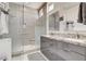 Modern bathroom featuring a double vanity with gray cabinets and a glass-enclosed shower at 3120 Darby Falls Dr, Las Vegas, NV 89134