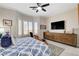 Relaxing main bedroom with a dresser, TV, and ample natural light from large windows at 3120 Darby Falls Dr, Las Vegas, NV 89134