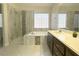 Bright bathroom featuring a walk-in shower, soaking tub, decorative tile accents, and a vanity at 33 Hatten Bay St, Henderson, NV 89012