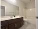 Full bathroom featuring a vanity, mirror, and shower-tub combination in a neutral color palette at 33 Hatten Bay St, Henderson, NV 89012