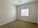 Light-filled bedroom with window and neutral carpet and walls at 33 Hatten Bay St, Henderson, NV 89012