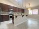 Modern kitchen with granite countertops, dark cabinets, and stainless steel appliances at 33 Hatten Bay St, Henderson, NV 89012