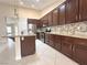 Stylish kitchen with dark wood cabinets, stainless steel appliances, and tile backsplash at 33 Hatten Bay St, Henderson, NV 89012