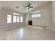 Spacious living room features tile flooring, a ceiling fan and a cozy fireplace, perfect for entertaining at 33 Hatten Bay St, Henderson, NV 89012