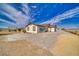 Rear exterior view of home with a large, gravel backyard and bright blue sky at 3301 Underbrush Ave, Pahrump, NV 89048