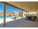 Inviting covered back patio with comfortable seating, overlooking a sparkling pool and well-maintained yard at 3568 E Malheur Ave, Pahrump, NV 89061