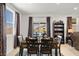 Inviting dining area with sliding door to the pool, decorative curtains and a well-placed bookshelf at 3568 E Malheur Ave, Pahrump, NV 89061