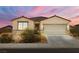Charming single-story home showcasing a well-manicured front yard, complemented by a two-car garage at 3568 E Malheur Ave, Pahrump, NV 89061