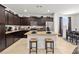 Modern kitchen features dark cabinetry, a granite island with barstool seating, and stainless steel appliances at 3568 E Malheur Ave, Pahrump, NV 89061