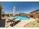 Stunning pool with water feature, surrounded by lush landscaping and lounge chairs for ultimate relaxation at 3568 E Malheur Ave, Pahrump, NV 89061
