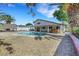 Large backyard featuring a pool, hot tub, gravel landscaping, lush palm trees and covered patios at 3746 E Harmon Ave, Las Vegas, NV 89121