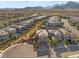 An aerial view of a vibrant community, featuring modern homes and desert landscaping against a backdrop of majestic mountains at 389 Red Feather Peak Ct, Las Vegas, NV 89138