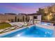 Backyard featuring a pristine pool, hot tub, BBQ area, and lush landscaping at 389 Red Feather Peak Ct, Las Vegas, NV 89138
