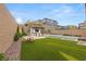 Expansive backyard with pool, outdoor kitchen, artificial lawn, and seating area at 389 Red Feather Peak Ct, Las Vegas, NV 89138